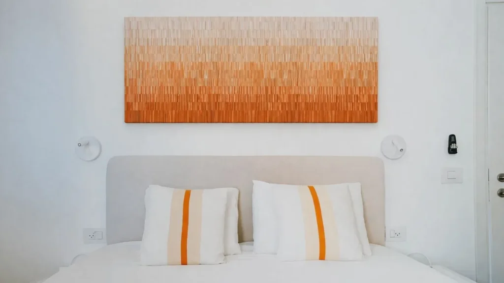 Œuvre en dégradé orange installée au-dessus du lit