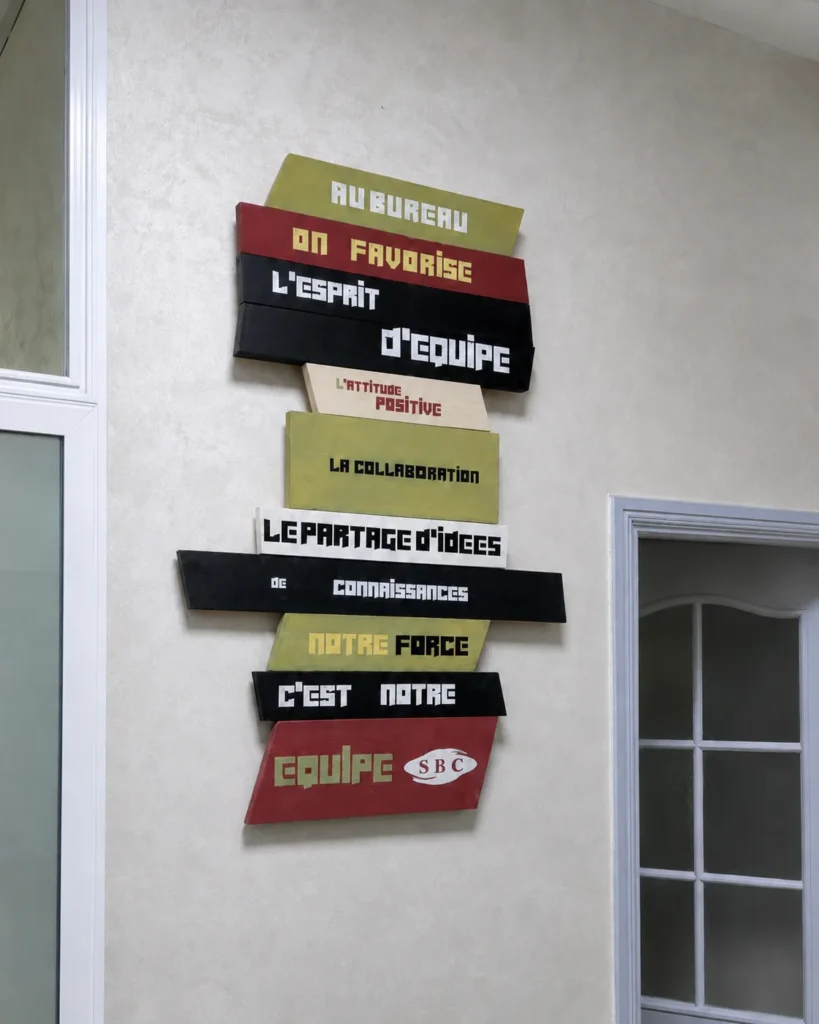 Œuvre typographique des valeurs d’équipe installée entre deux portes